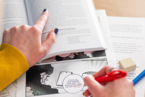 Person proofreading printed documents at a desk