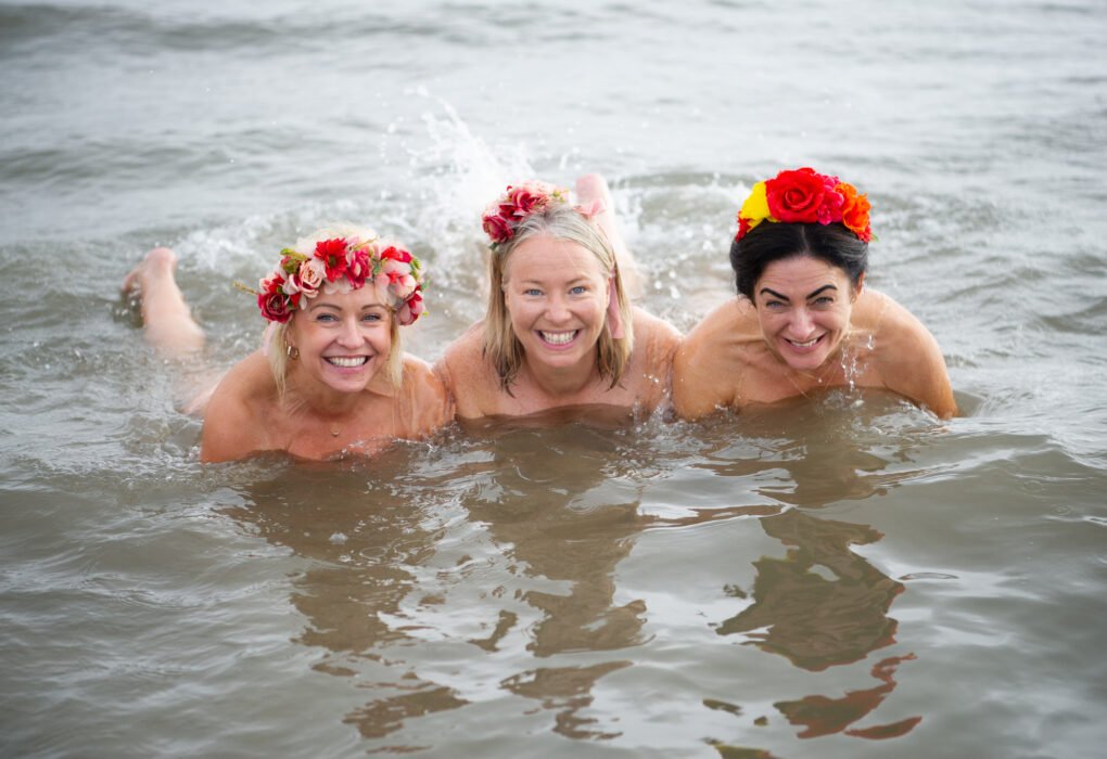 Three women taking part in the Northeast Dip in the Nip 2026