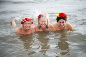 Three women taking part in the Northeast Dip in the Nip 2026