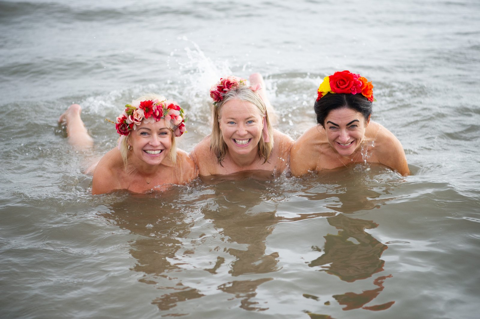 Three women taking part in the Northeast Dip in the Nip 2026