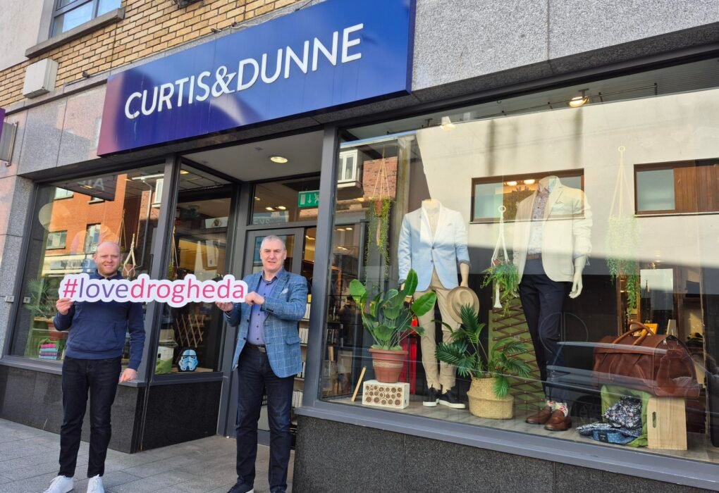 Two men outside Curtis & Dunne in Drogheda holding a Love Drogheda sign