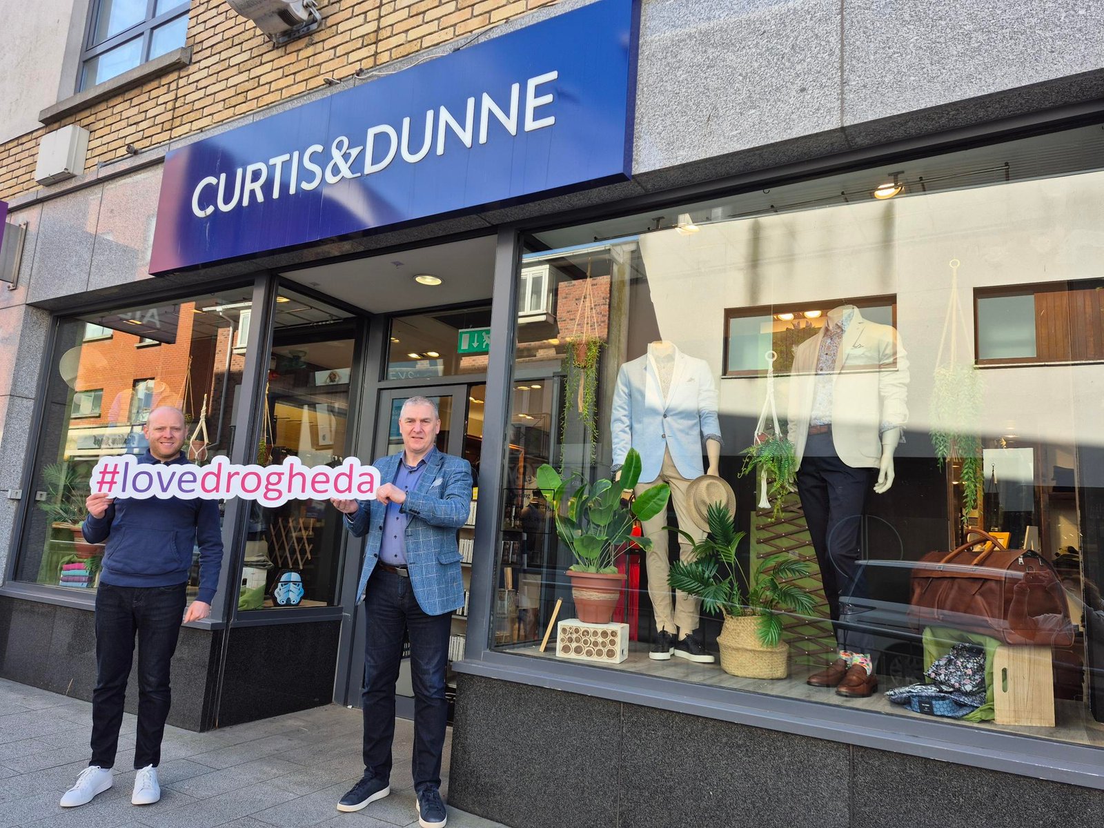 Curtis & Dunne is one of the local businesses where the Love Drogheda Gift Card can be spent. Two men outside Curtis & Dunne in Drogheda holding a Love Drogheda sign