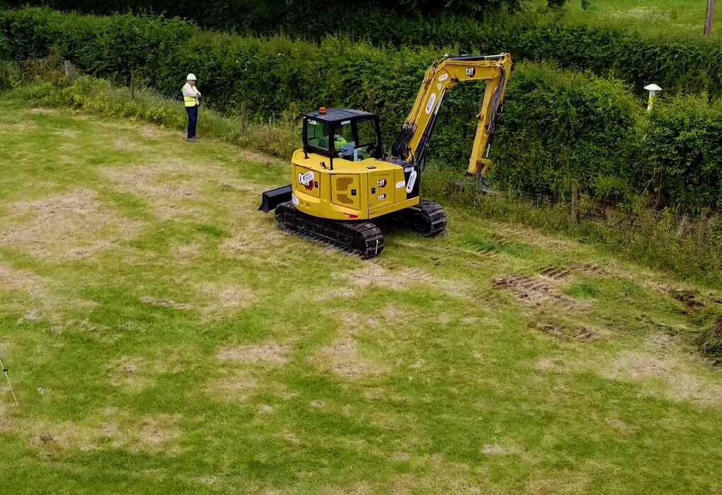 Excavator carrying out ditch clearing work beside a Gas Networks Ireland pipeline marker