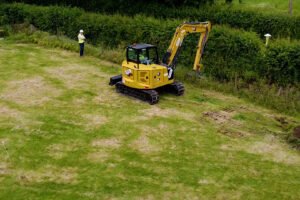 Excavator carrying out ditch clearing work beside a Gas Networks Ireland pipeline marker