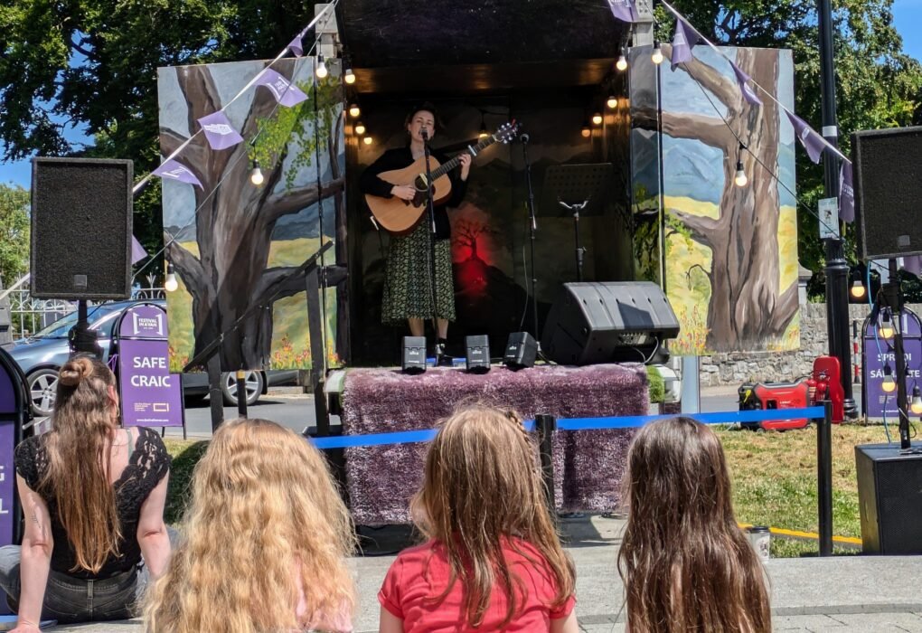 Musician performing from the Festival in a Van mobile stage for an outdoor audience