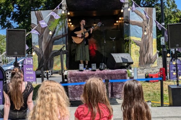 Musician performing from the Festival in a Van mobile stage for an outdoor audience