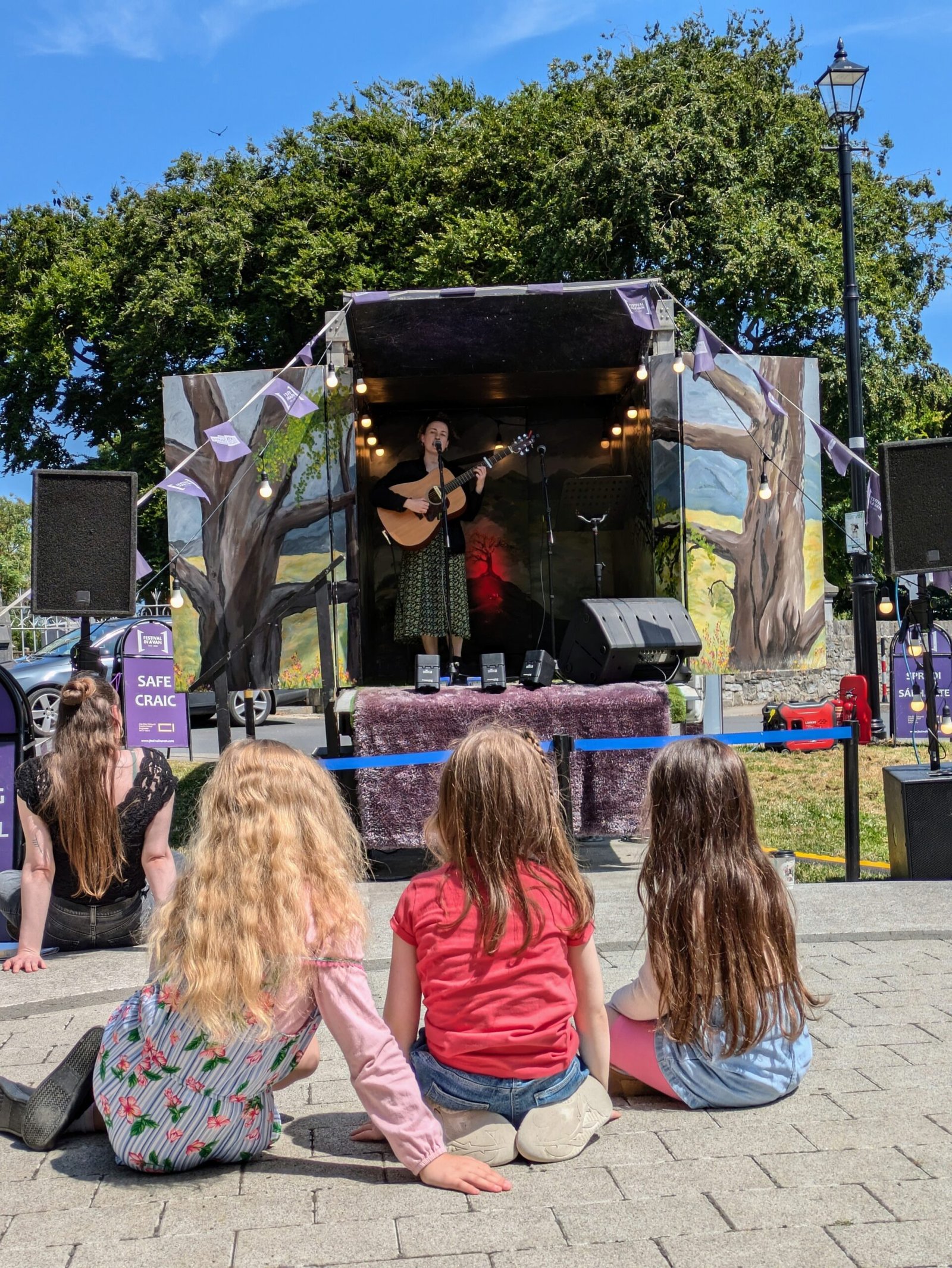 Musician performing from the Festival in a Van mobile stage for an outdoor audience