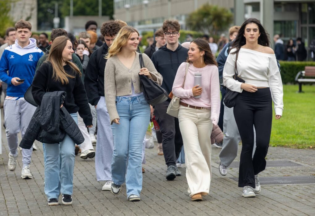New first-year students walking across the DkIT campus during induction