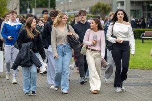 New first-year students walking across the DkIT campus during induction