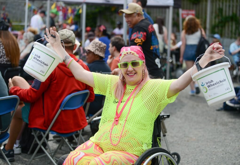 Nicola McDonnell from Irish Wheelchair Association Drogheda holding fundraising buckets at a community event